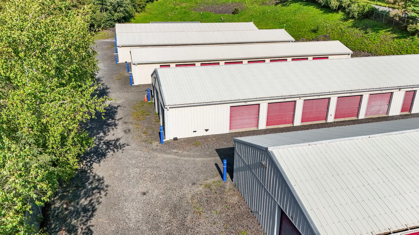 Aerial view of UrbanLock storage buildings in Scranton with tree-lined perimeter, showing multiple drive-up accessible units with red rollup doors