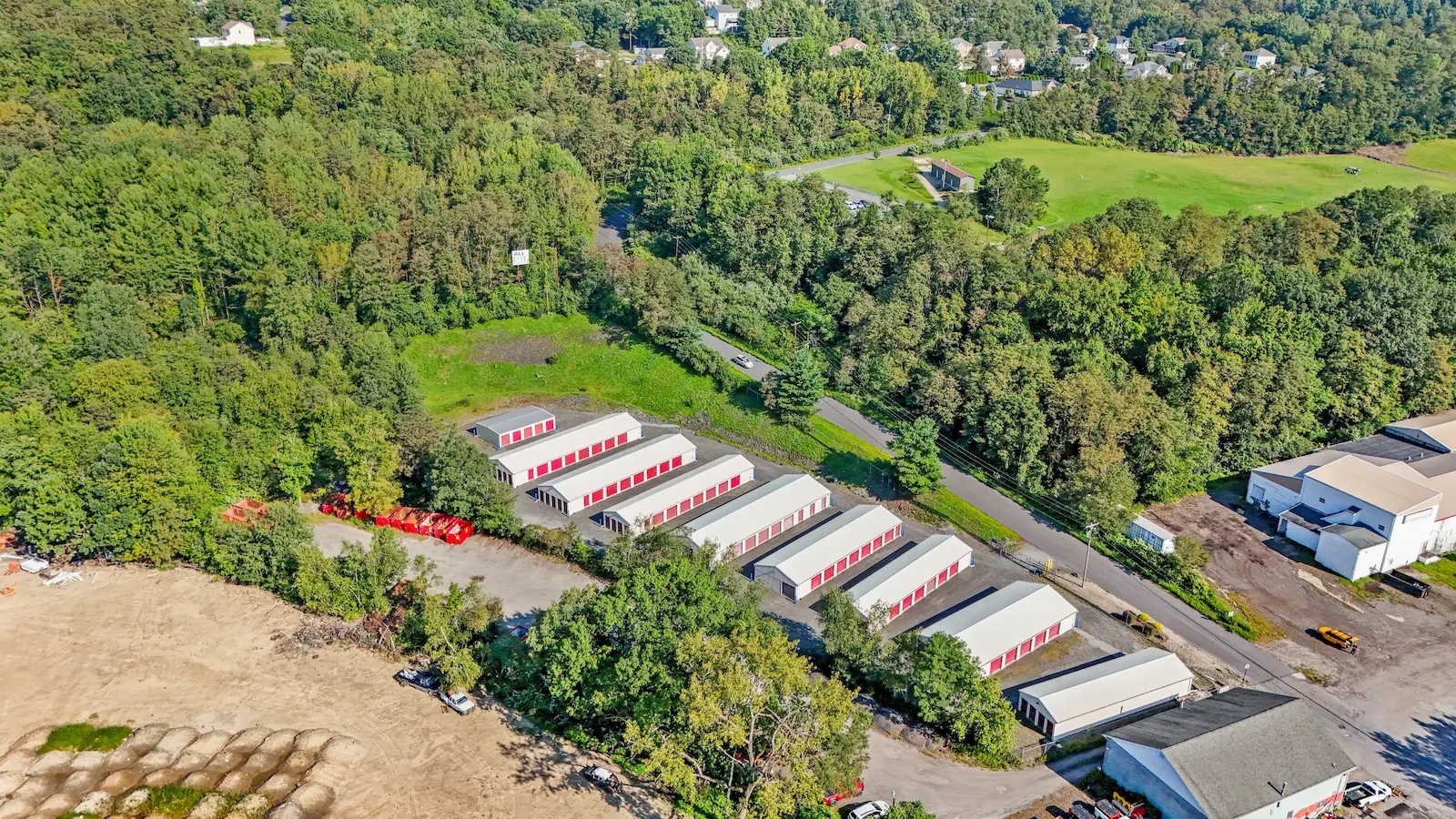 Aerial view of UrbanLock self-storage facility in Scranton nestled in wooded landscape, showing full campus of storage buildings and surrounding residential area
