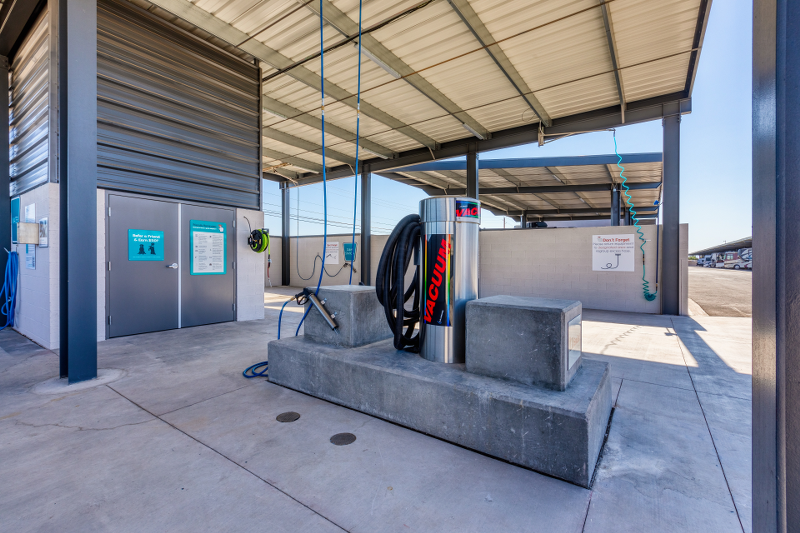 Covered utility station at Carefree Covered RV Storage in Maricopa, Arizona, featuring a commercial-grade vacuum, air hose, and water hookup—providing RV owners with convenient access to cleaning and maintenance tools before or after storage.