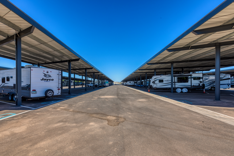 Wide drive aisles between covered RV parking rows at Carefree Covered RV Storage in Surprise, AZ