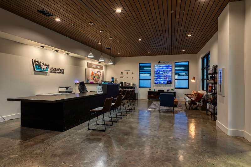 Modern interior of the Carefree welcome center featuring community seating and security monitors