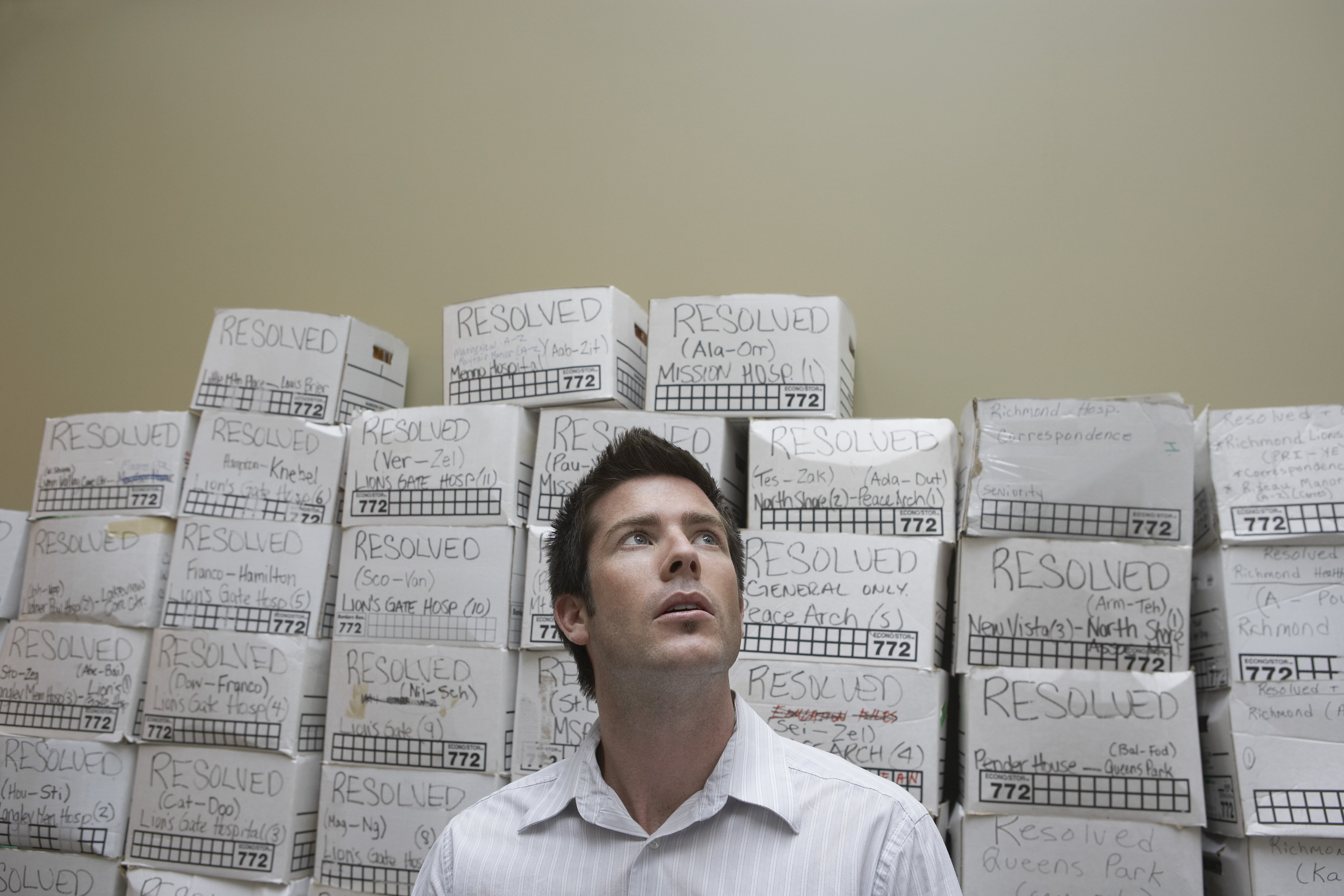 A business owner standing in front of boxes of files