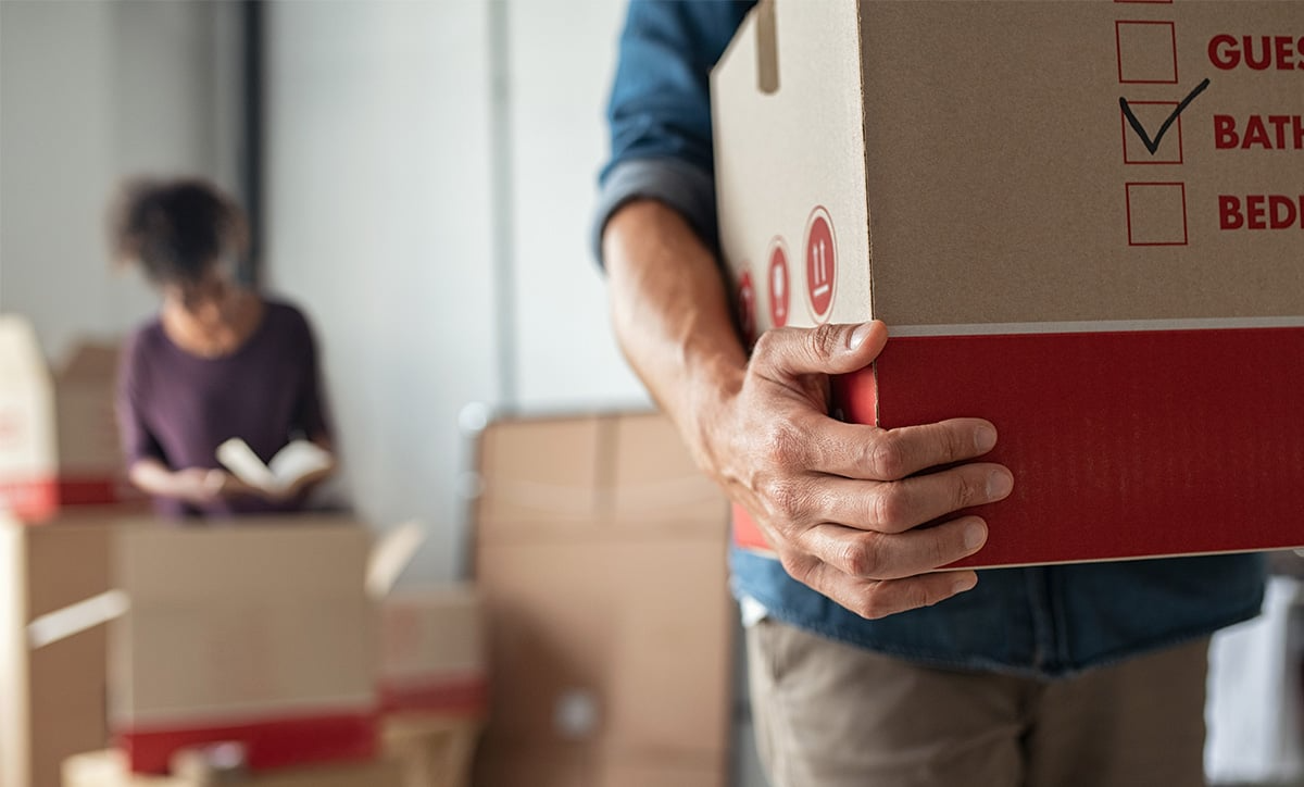 Person carrying a box to storage