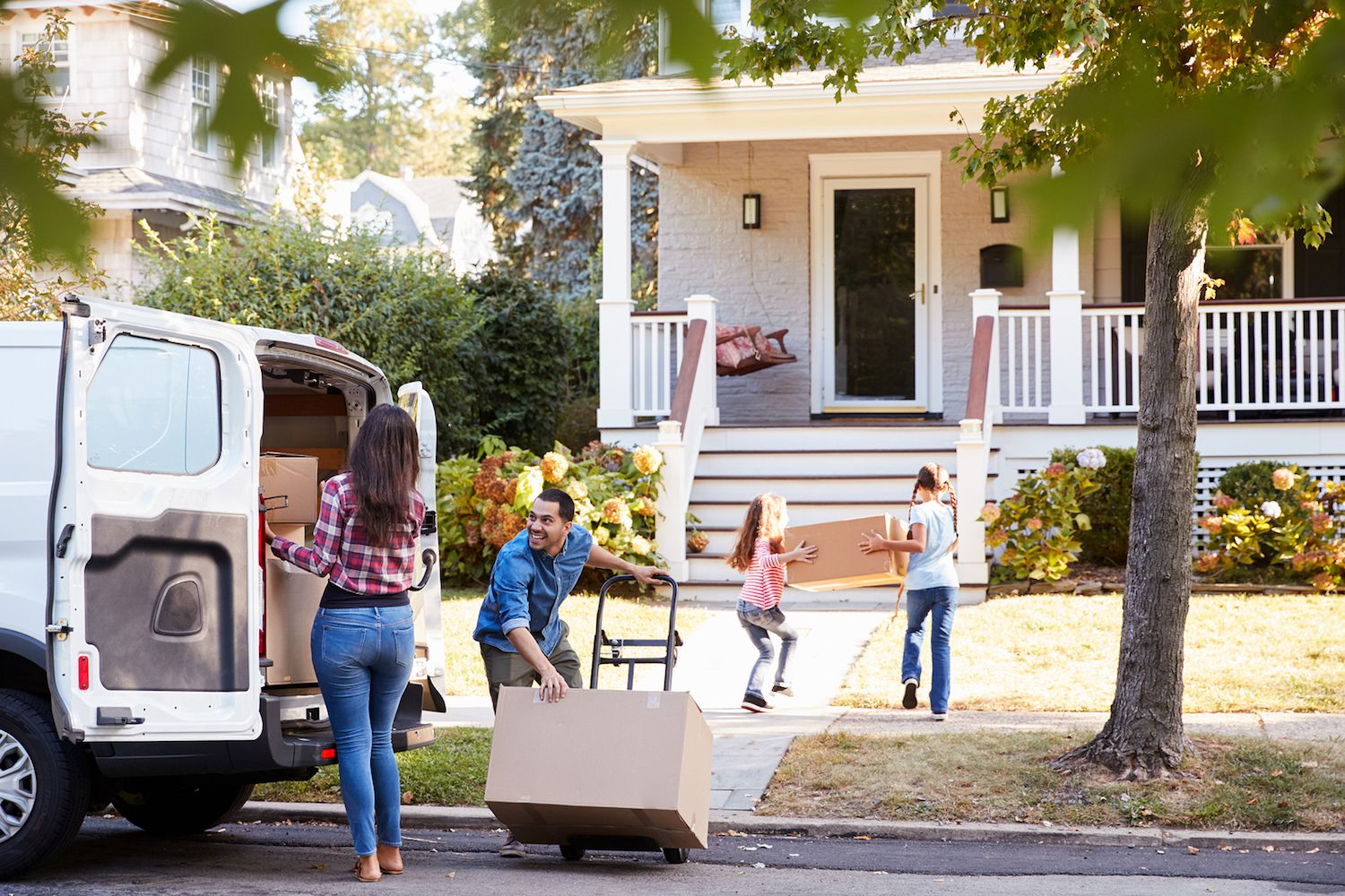 A family moving boxes into a house