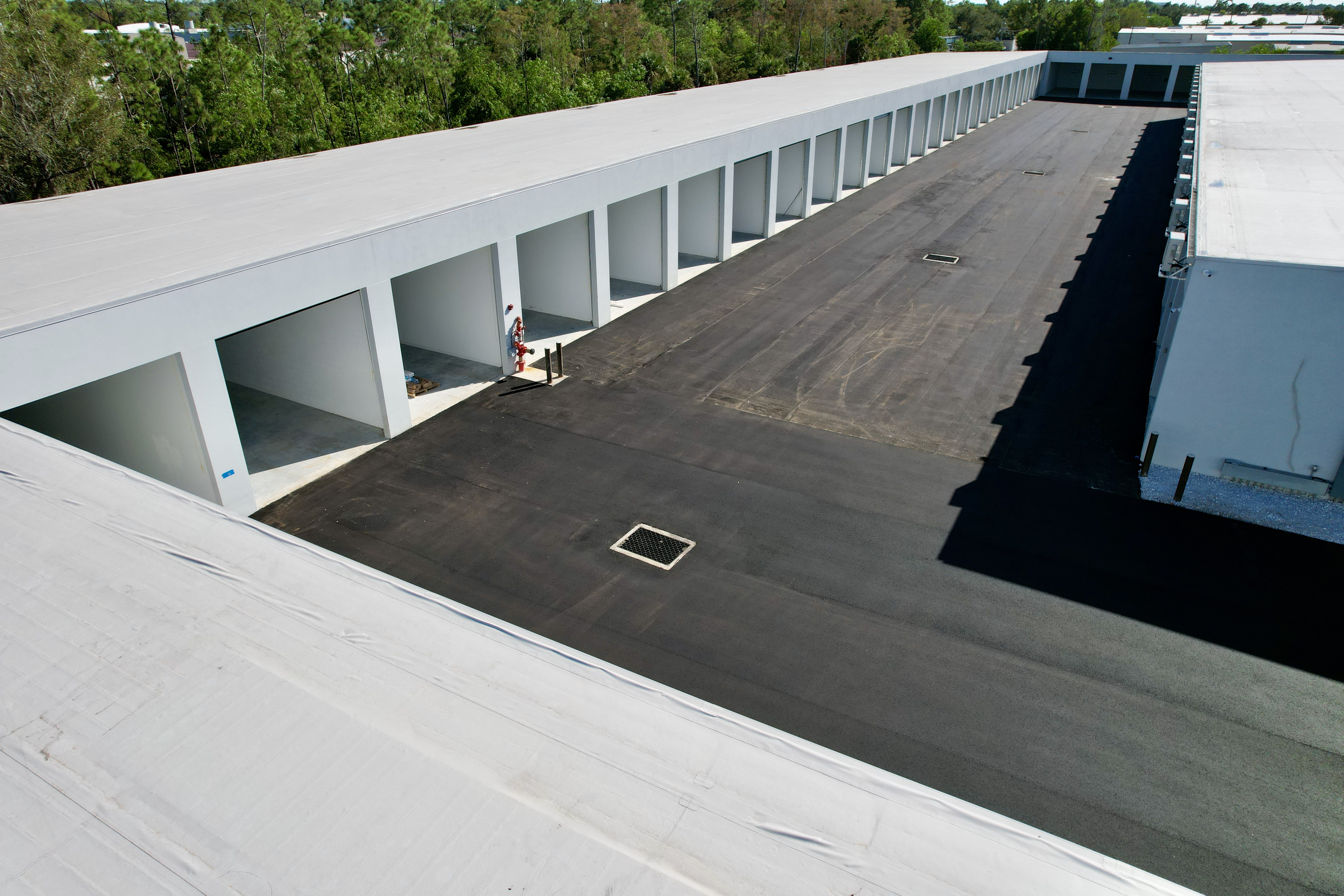 Aerial view of wide asphalt drive aisles and individual climate-controlled storage bays at Metro-Maxx RV and boat storage facility in Fort Myers, Florida