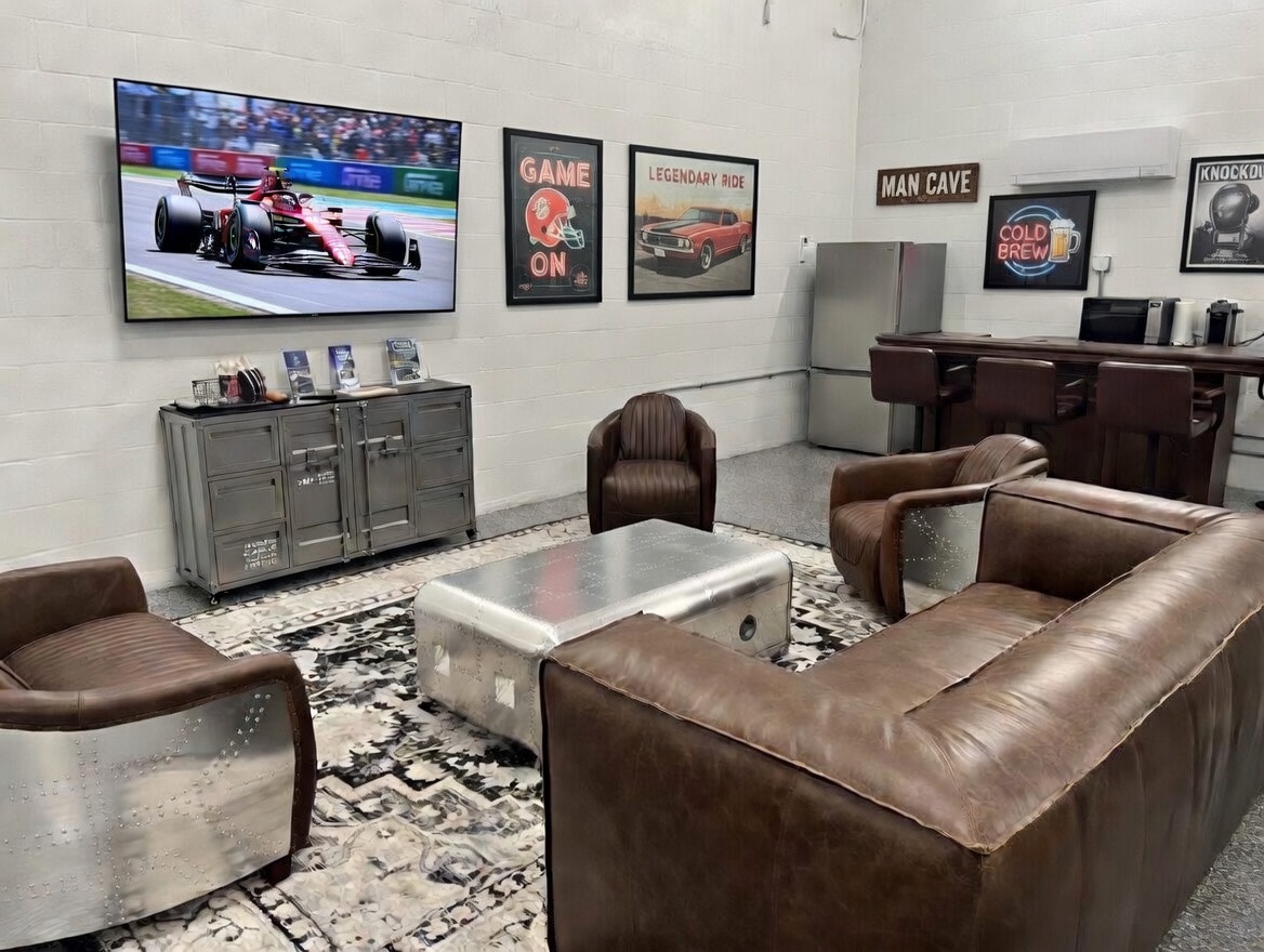 Private man cave lounge inside MetroMaxx RV and Boat Storage featuring leather seating, large TV, bar area, and climate-controlled indoor space in Fort Myers, Florida.