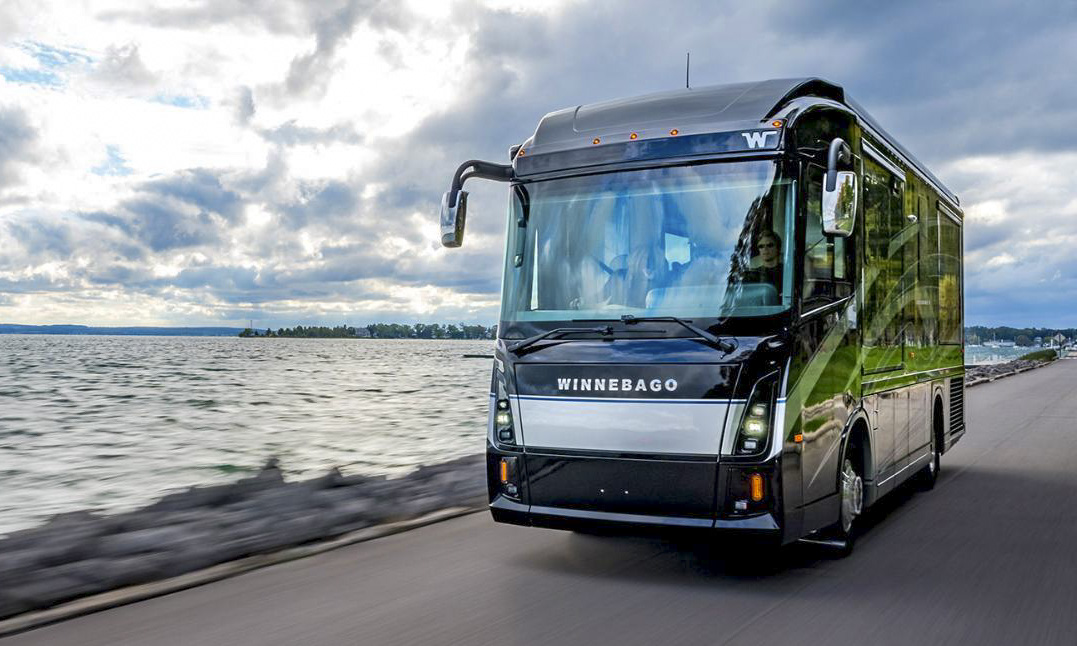Winnebago Journey Motorhome Driving Along the Waterfront Front view of a Winnebago Journey motorhome driving on a road beside a large body of water under a cloudy sky