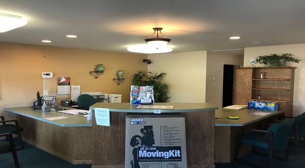 inside stop-n-stor northwood office with large front desk and counter, moving kit merchandise displayed Stop-N-Stor Northwood Storage Facility Office and Front Desk