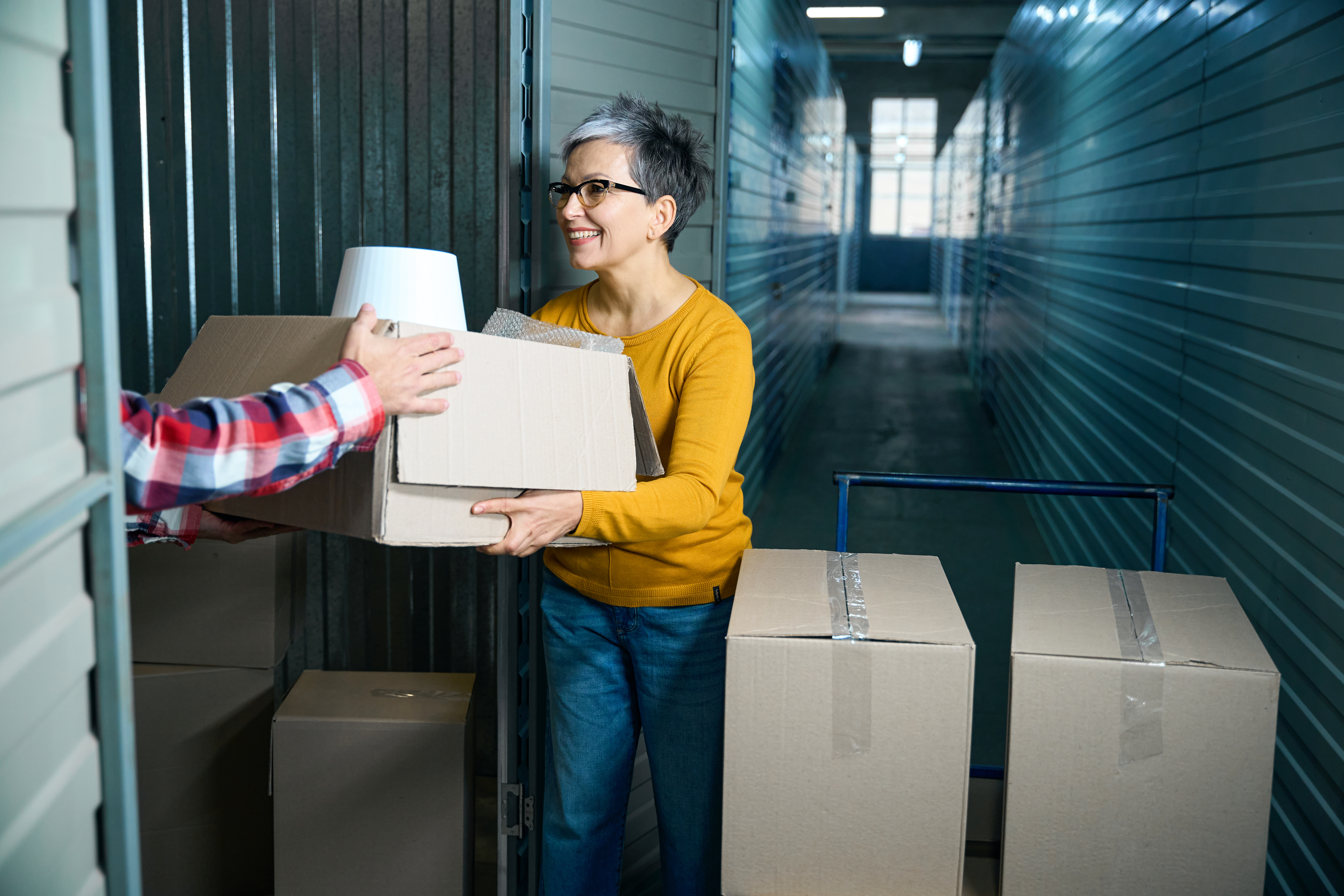 Woman moving boxes into a self storage unit