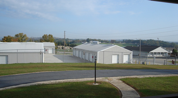 wide shot of self storage facility, buildings behind fence and gate