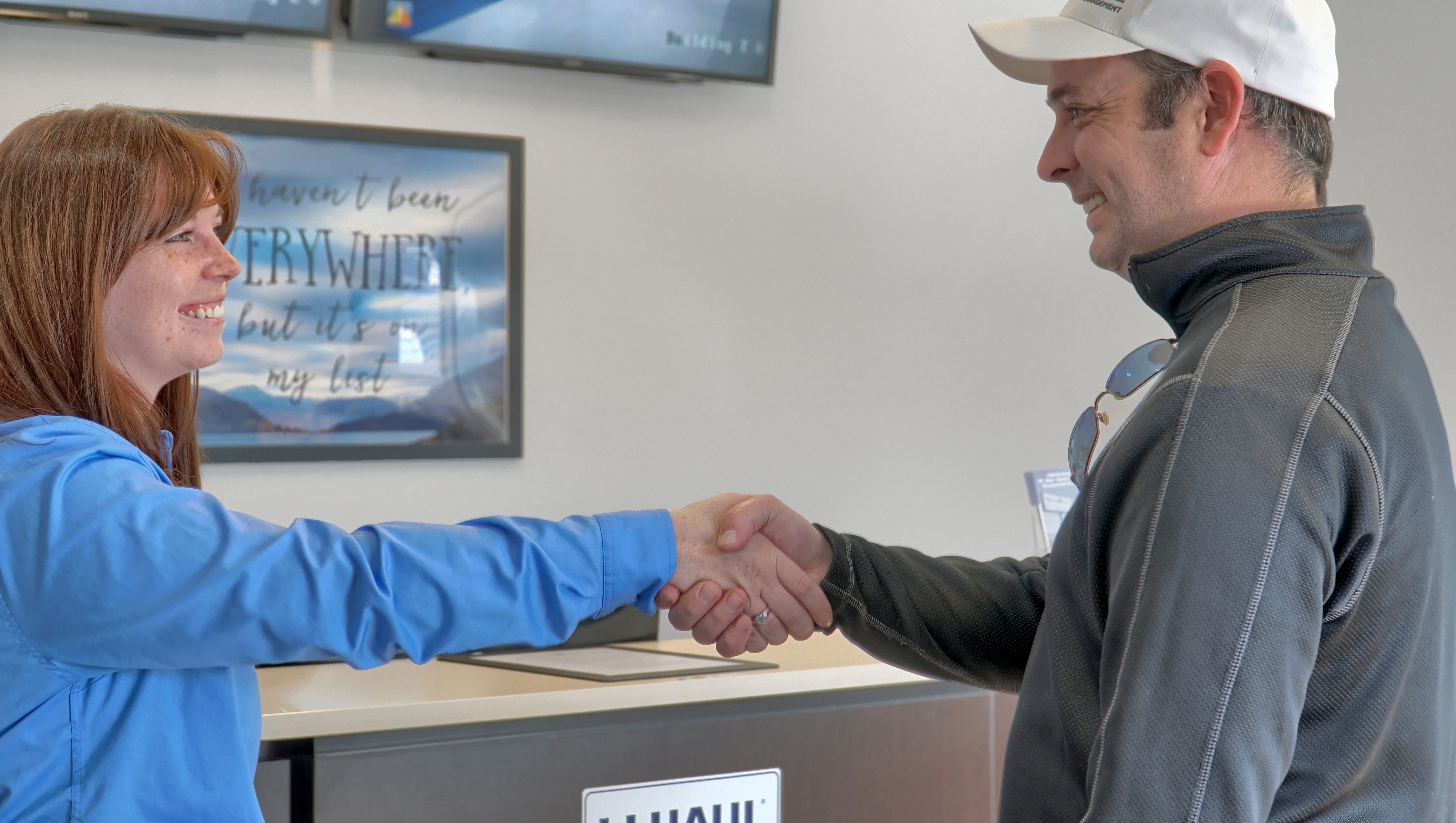 female employee shaking hands with male customer in office