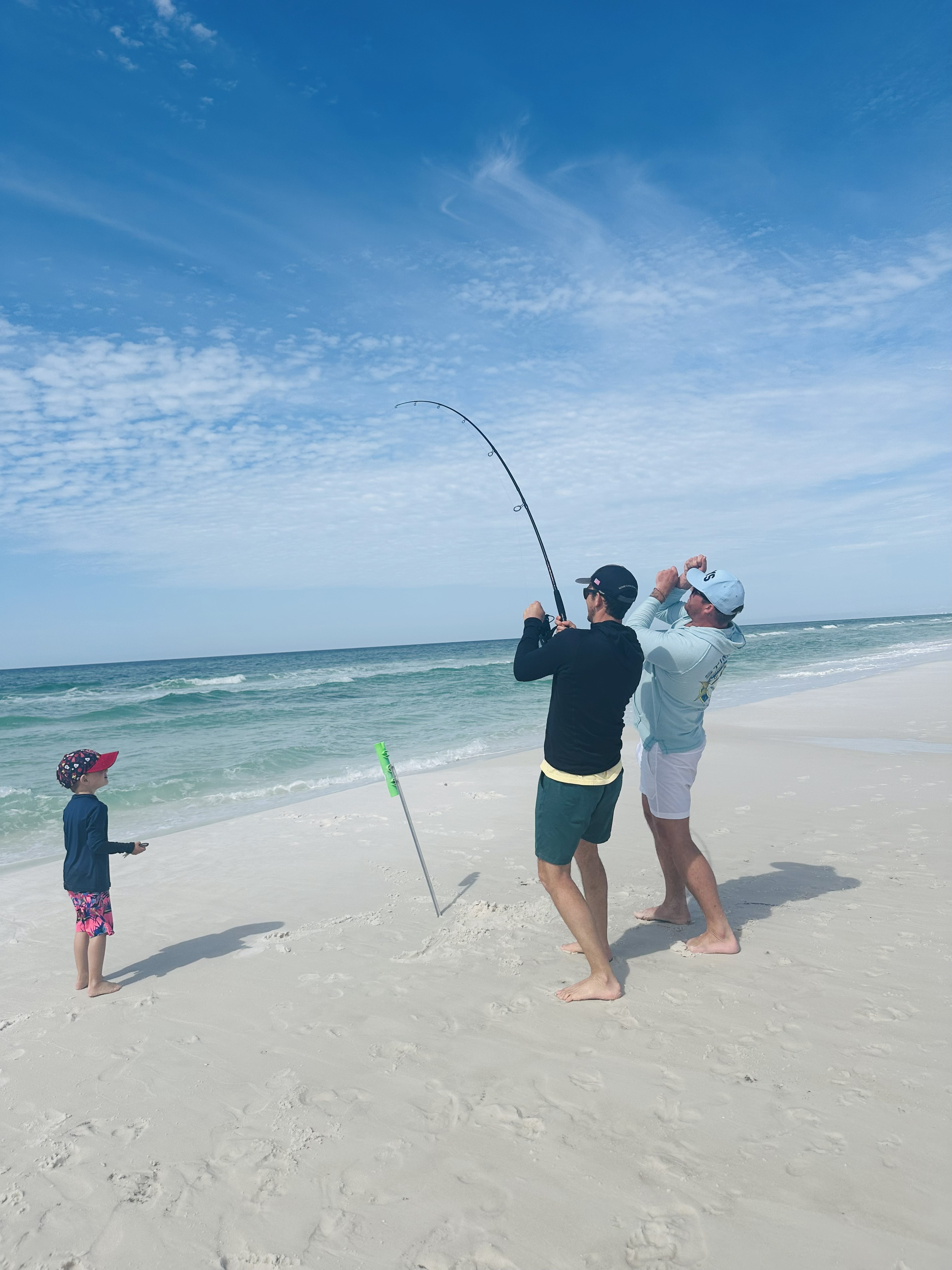 Adults Teaching Boy Surf Fishing in Santa Rosa Beach, FL