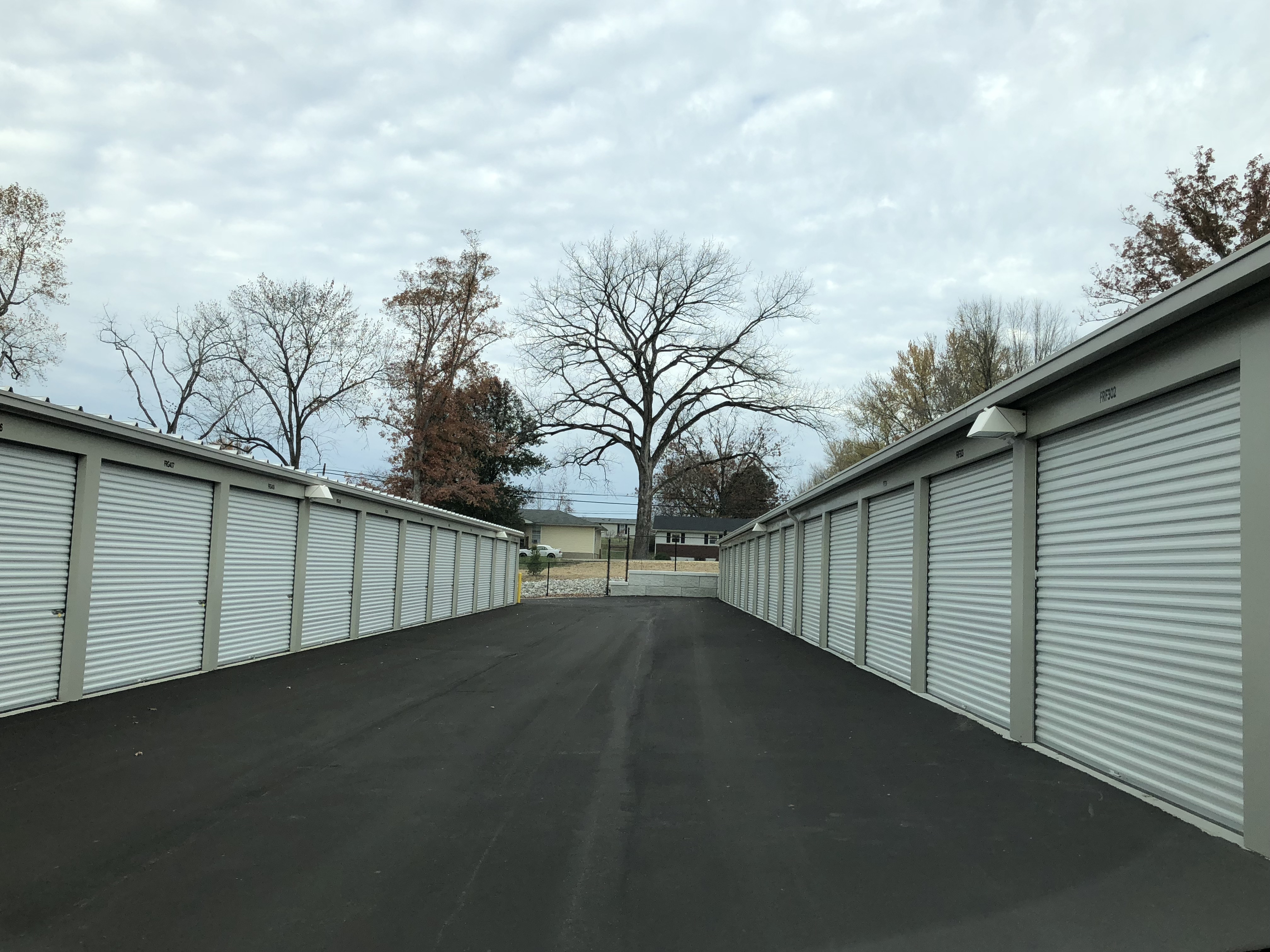 Wide driveways and white-door units at Budd Road's gated Access Storage location, ensuring secure and convenient storage.
