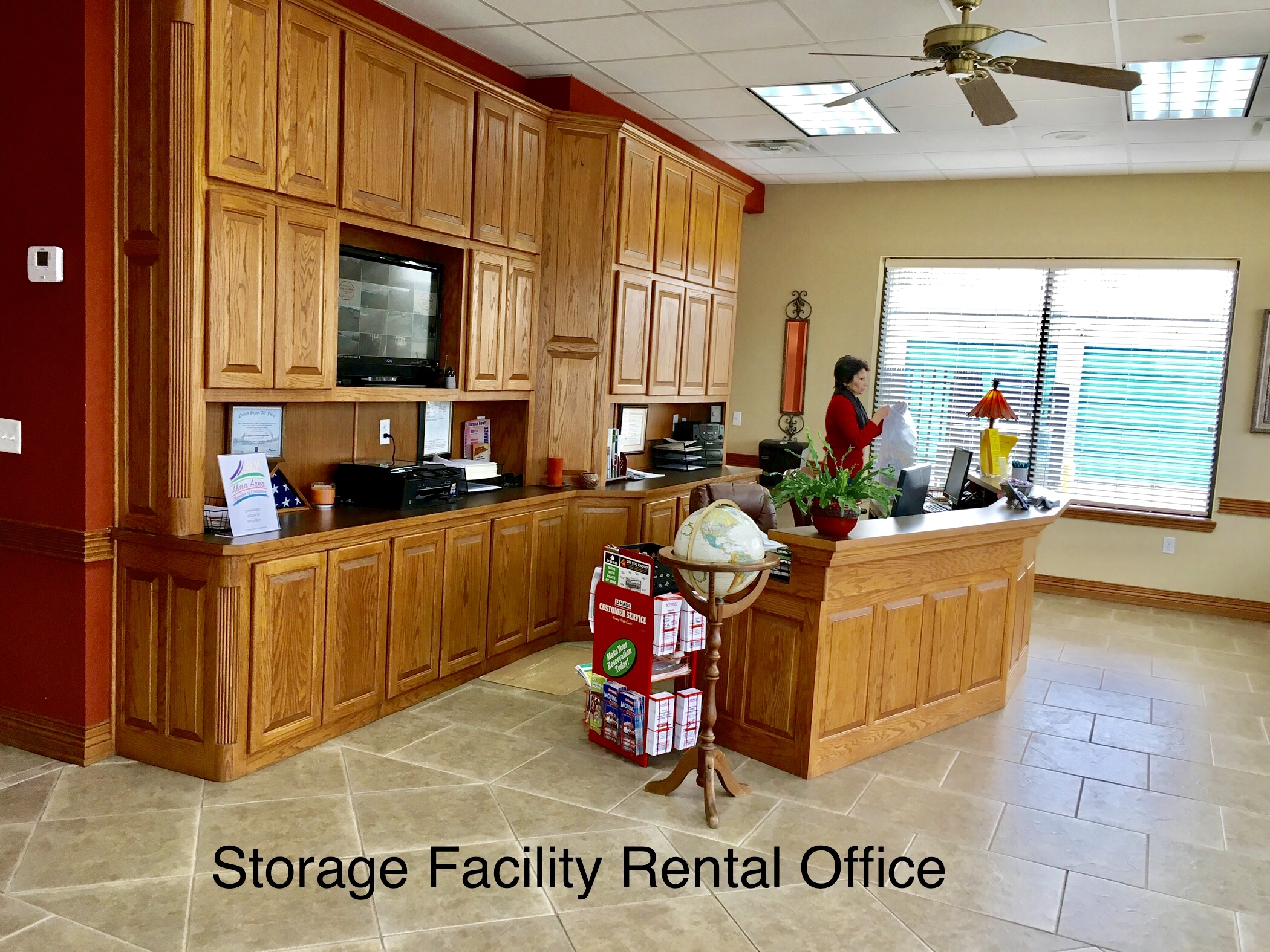 Visit with our friendly staff with any questions you might have interior of storage facility rental office with manager standing behind desk