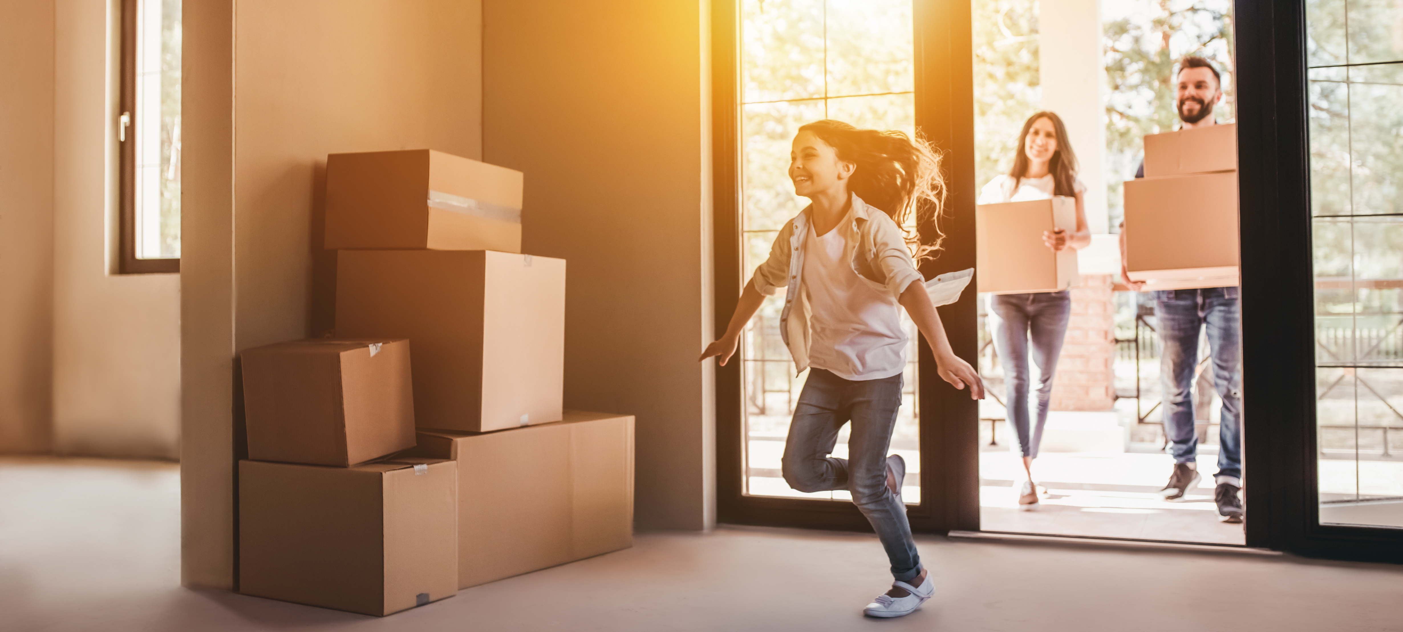 family entering home with moving boxes