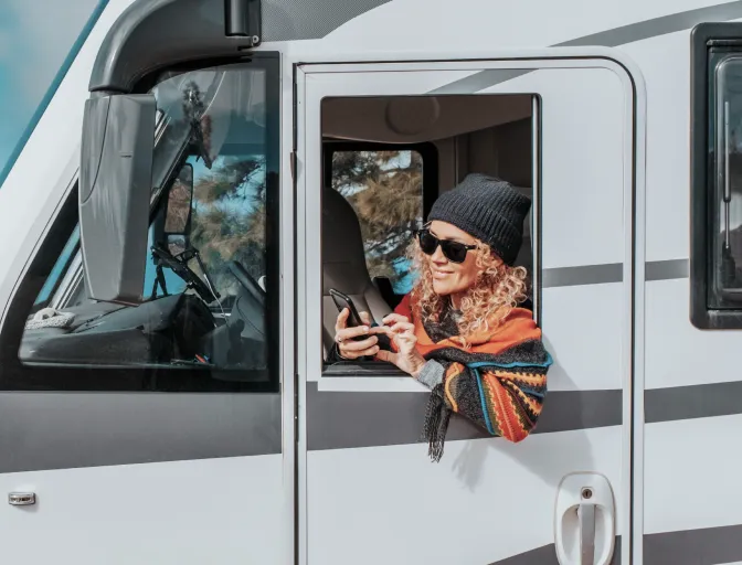 Woman leaning out window of a parked RV